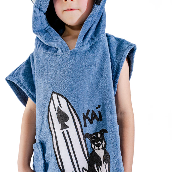 Détail illustration Kaï et sa planche brodée sur poncho surf bébé ALL-IN Kaï Surf Blue