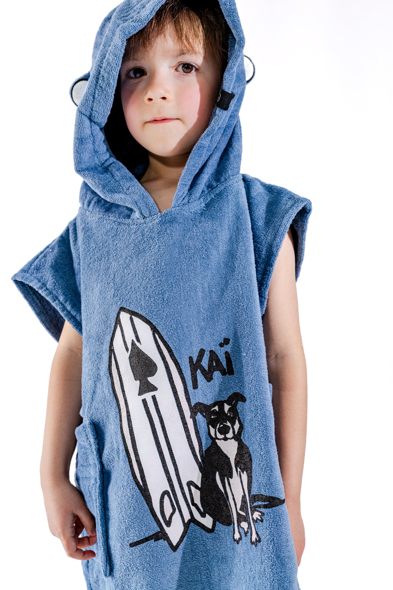Détail illustration Kaï et sa planche brodée sur poncho surf bébé ALL-IN Kaï Surf Blue