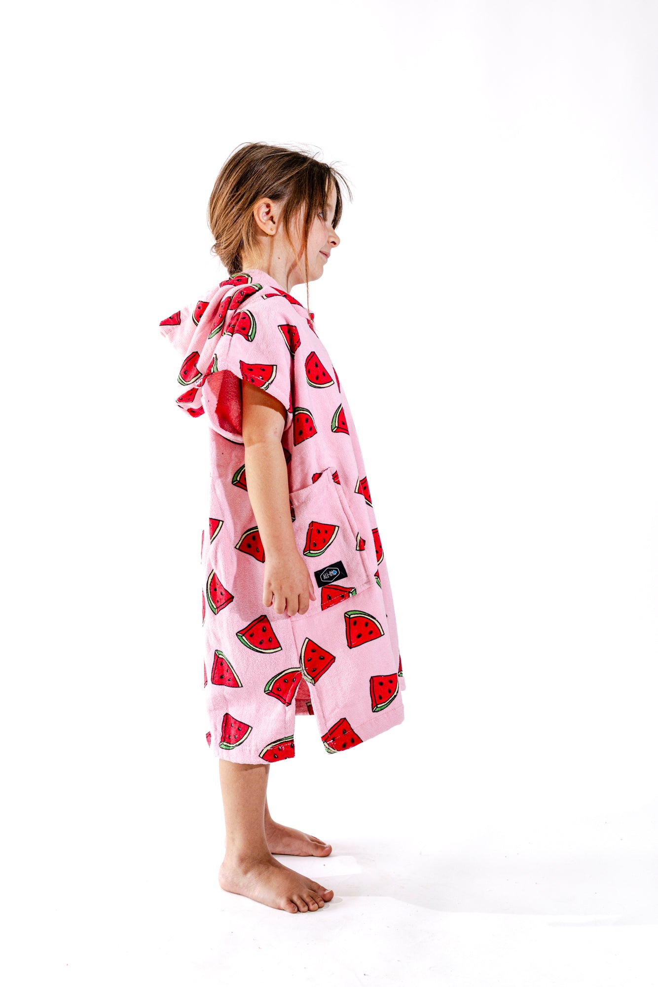 Poncho surf enfant ALL-IN Watermelon vue de profil, motif pastèques coloré, coupe ample rose