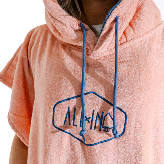 Poncho ALL-IN Classic Corail Blue, détail logo hexagone et cordons bleus, éponge coton corail