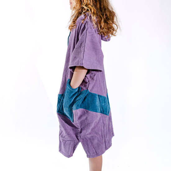 Poncho surf junior ALL-IN Nirvana vue de profil, coupe ample, coloris violet et bleu pétrole