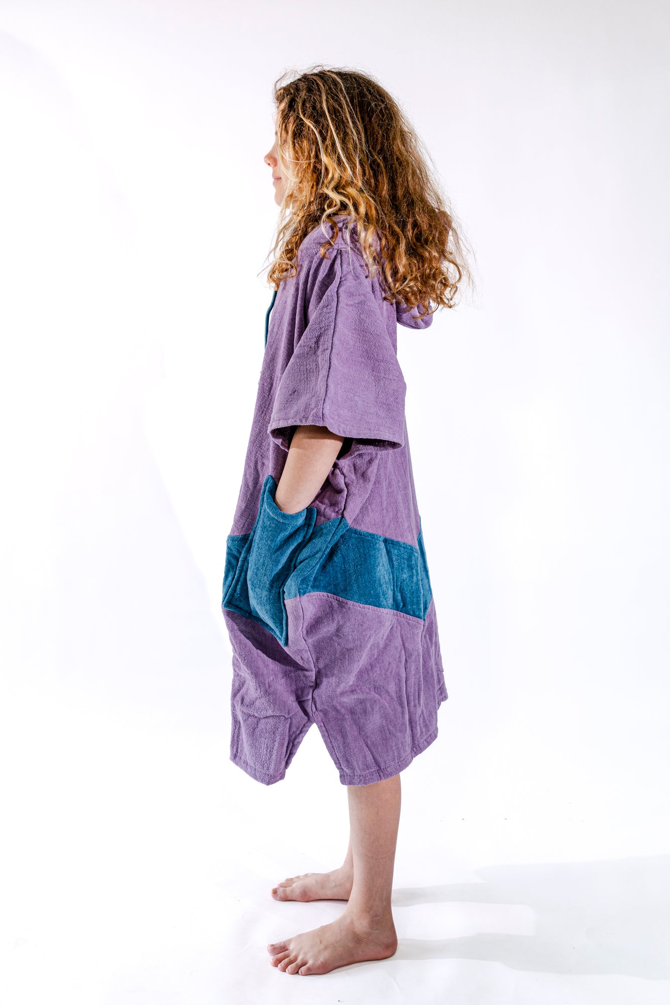 Poncho surf junior ALL-IN Nirvana vue de profil, coupe ample, coloris violet et bleu pétrole