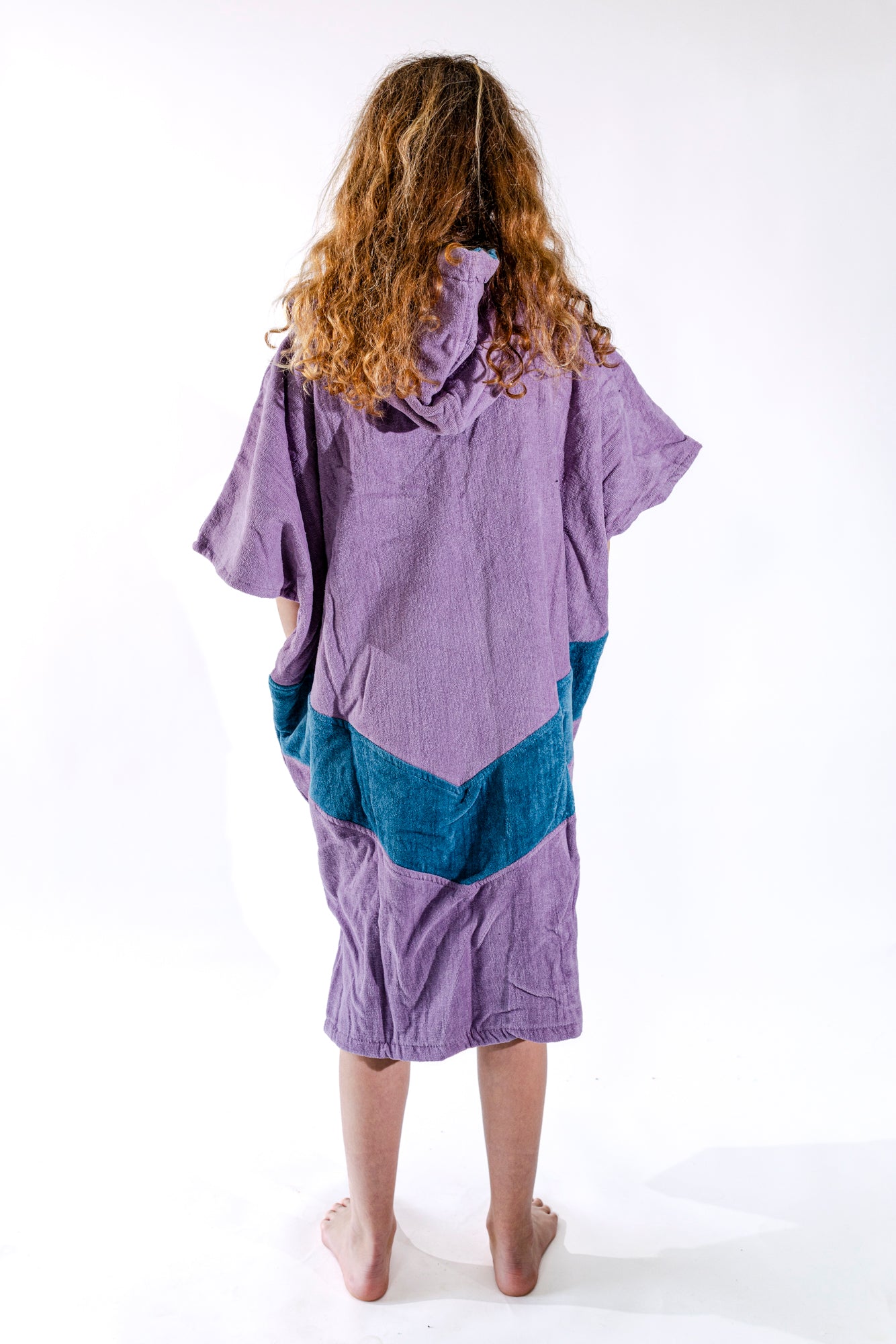 Dos du poncho surf junior ALL-IN Nirvana, coloris violet avec poches et bande bleu pétrole