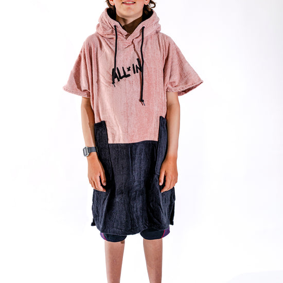 Poncho surf junior ALL-IN Kaï Surf vue de face, coloris rose poudré et bas marine, logo brodé, 9-15 ans