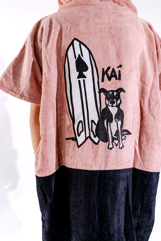 Illustration exclusive Kaï et sa planche brodée sur poncho surf junior ALL-IN Kaï Surf rose poudré