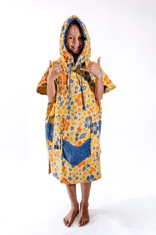 Poncho surf enfant ALL-IN Flore capuche relevée, motif floral jaune et orange, poches bleues, 6-9 ans