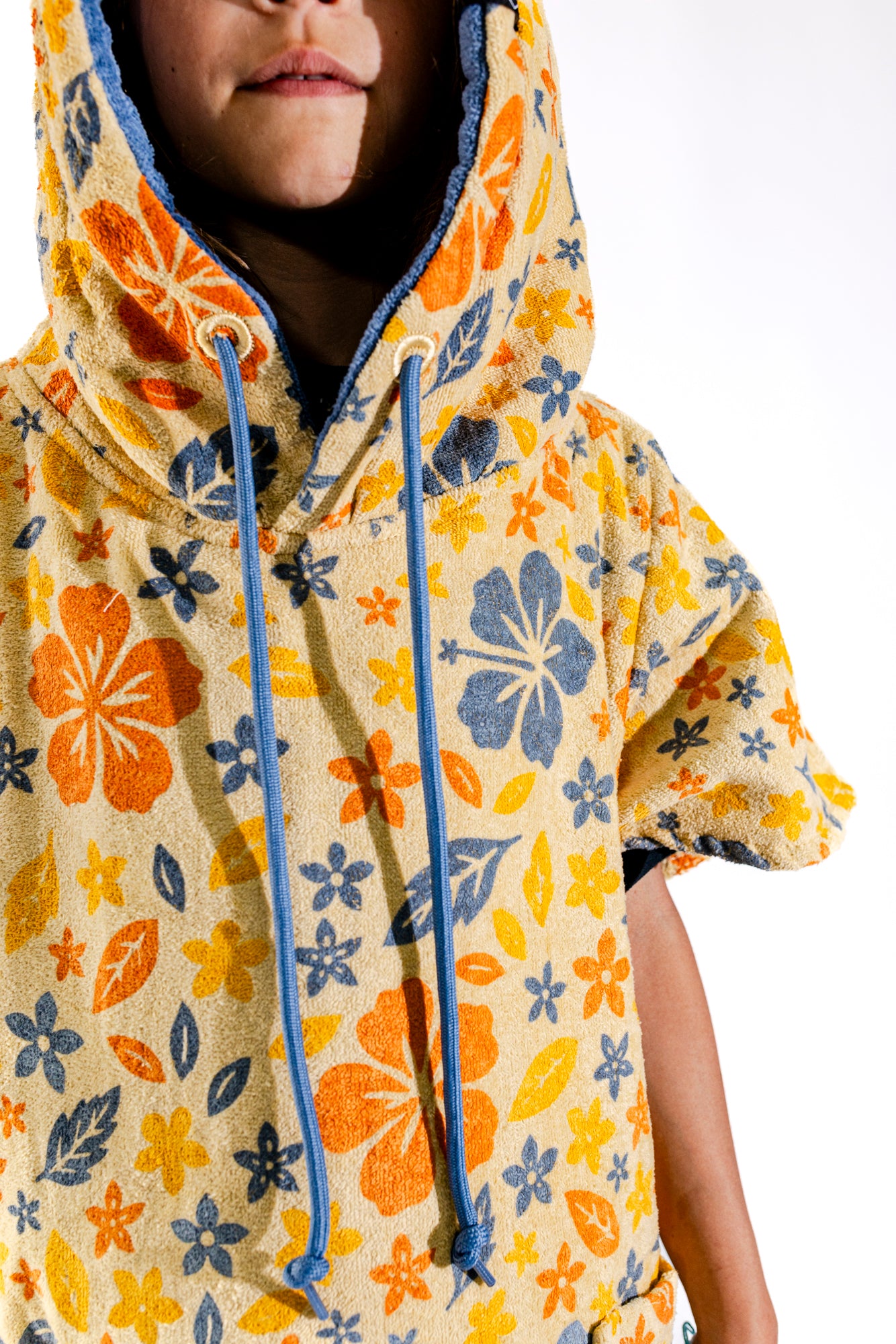 Détail capuche doublée et motif floral du poncho surf enfant ALL-IN Flore, cordon bleu contrasté