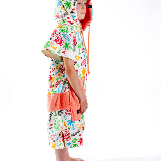 Dos du poncho surf enfant ALL-IN Skully, motif multicolore têtes de mort, capuche doublée saumon