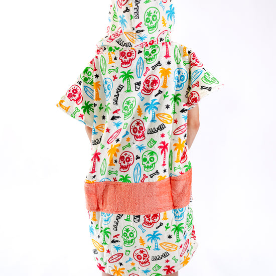 Poncho surf enfant ALL-IN Skully vue de profil, coupe ample, motif coloré et poches saumon