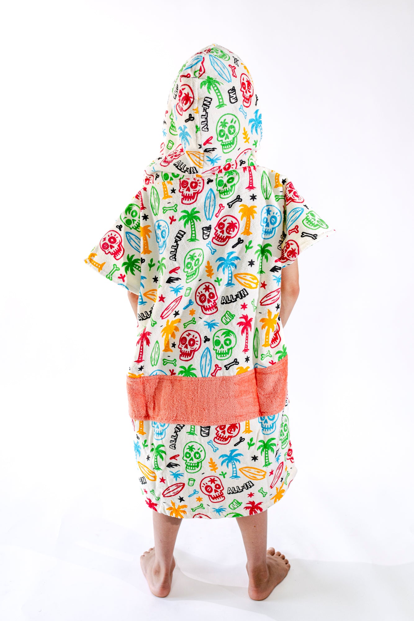 Poncho surf enfant ALL-IN Skully vue de profil, coupe ample, motif coloré et poches saumon