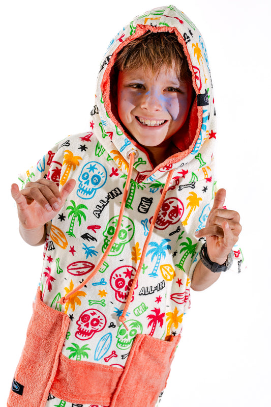 Poncho surf enfant ALL-IN Skully capuche relevée, motif têtes de mort colorées et palmiers, 6-9 ans