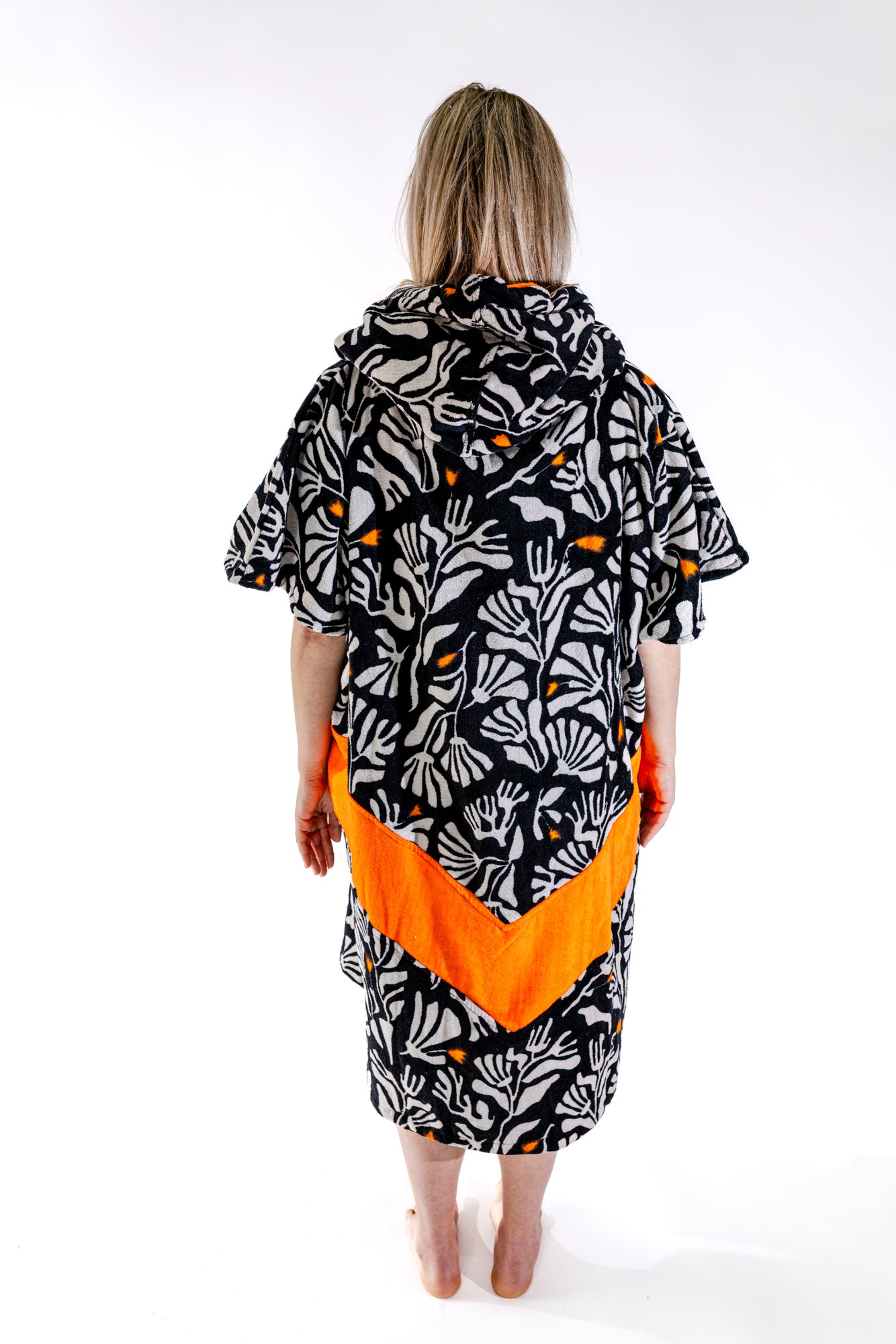 Dos du poncho surf adulte ALL-IN Corail, motif floral noir et blanc, poches orange visibles