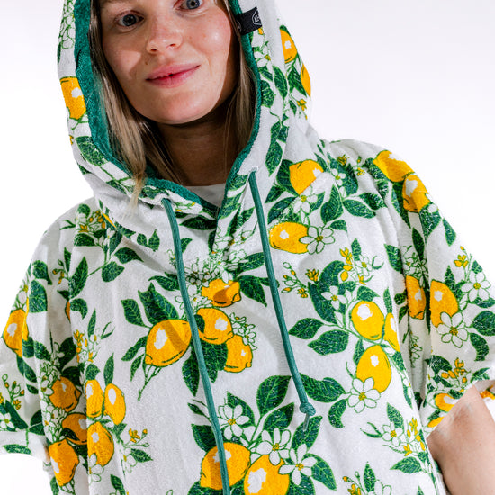 Détail poches vertes et motif citrons du poncho surf femme ALL-IN Lemonade, tissu 100% coton éponge