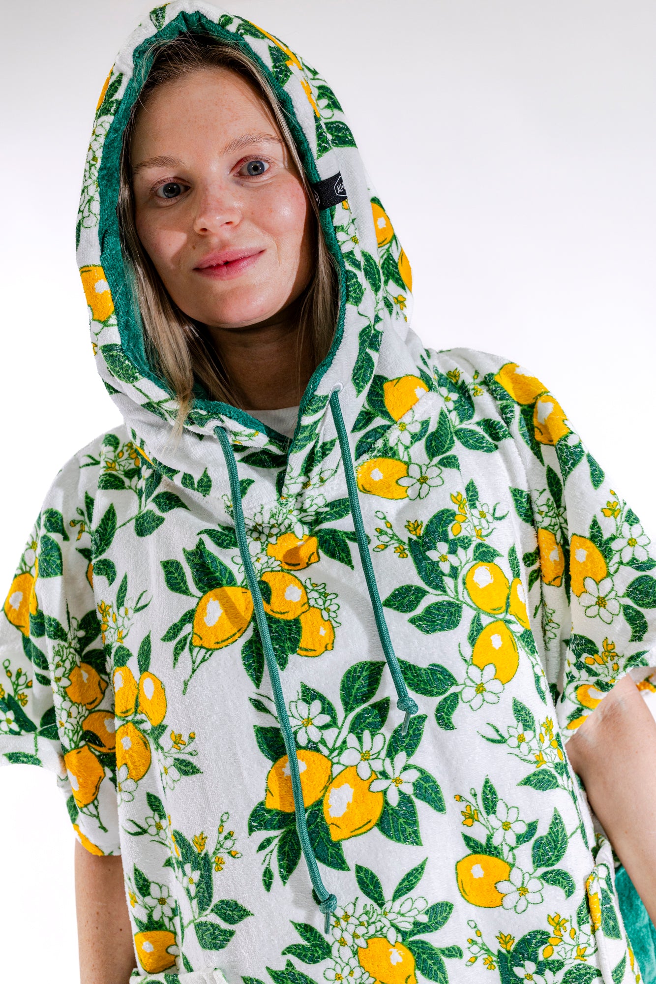 Détail poches vertes et motif citrons du poncho surf femme ALL-IN Lemonade, tissu 100% coton éponge