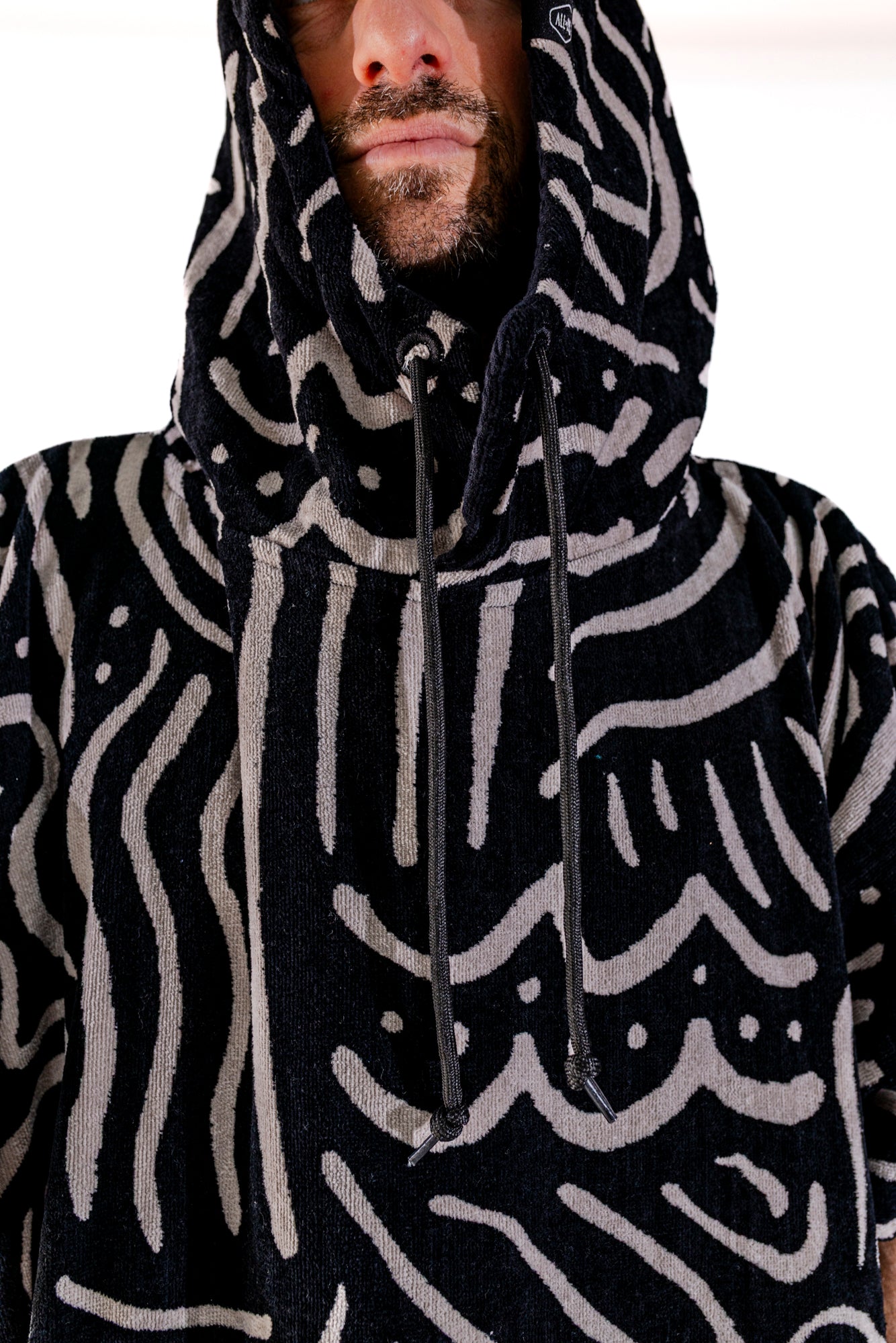 Détail capuche et col du poncho surf ALL-IN Matis Black, motif graphique noir et blanc