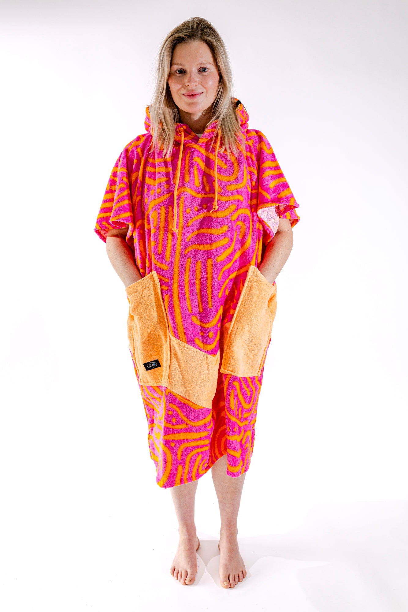 Poncho surf femme ALL-IN Matis Rose vue de face, motif zébré rose et orange, poches orange vif