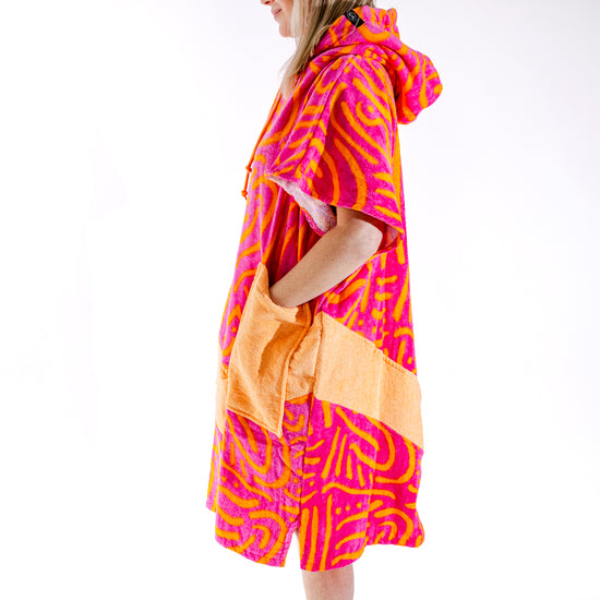 Poncho surf femme ALL-IN Matis Rose vue de profil, coupe V-Shape, motif zébré rose et orange