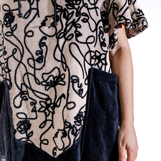 Détail poches noires et motif Oneline du poncho surf adulte ALL-IN, tissu 100% coton éponge