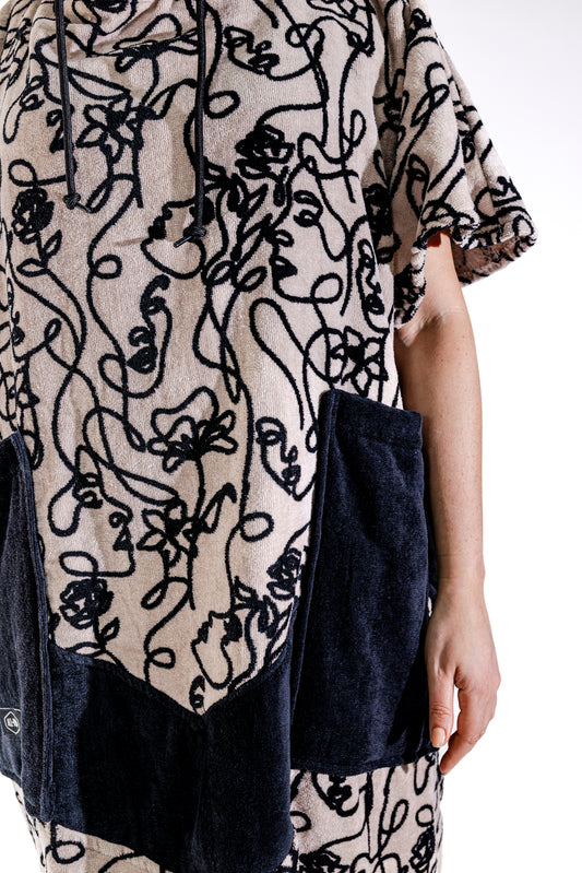 Détail poches noires et motif Oneline du poncho surf adulte ALL-IN, tissu 100% coton éponge