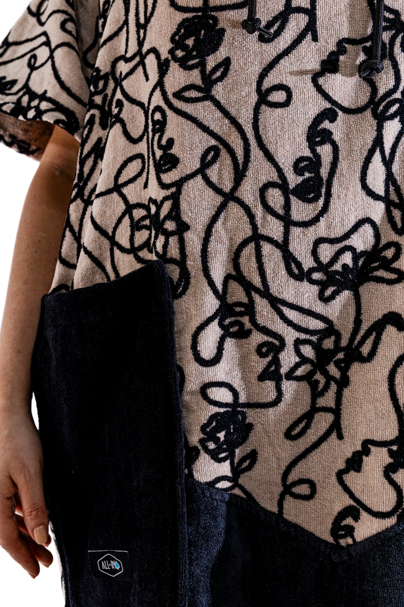 Poncho surf adulte ALL-IN Oneline vue de profil, coupe V-Shape ample, motif graphique beige et noir