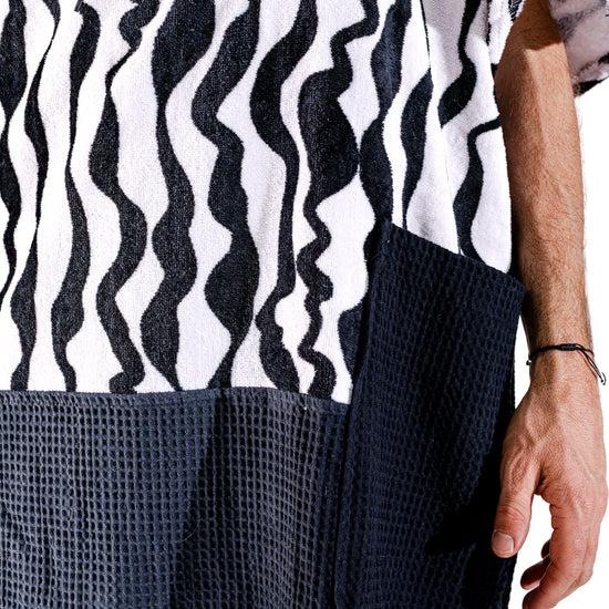 Détail poches waffle noires et motif zébré noir et blanc du poncho surf adulte ALL-IN Stripes