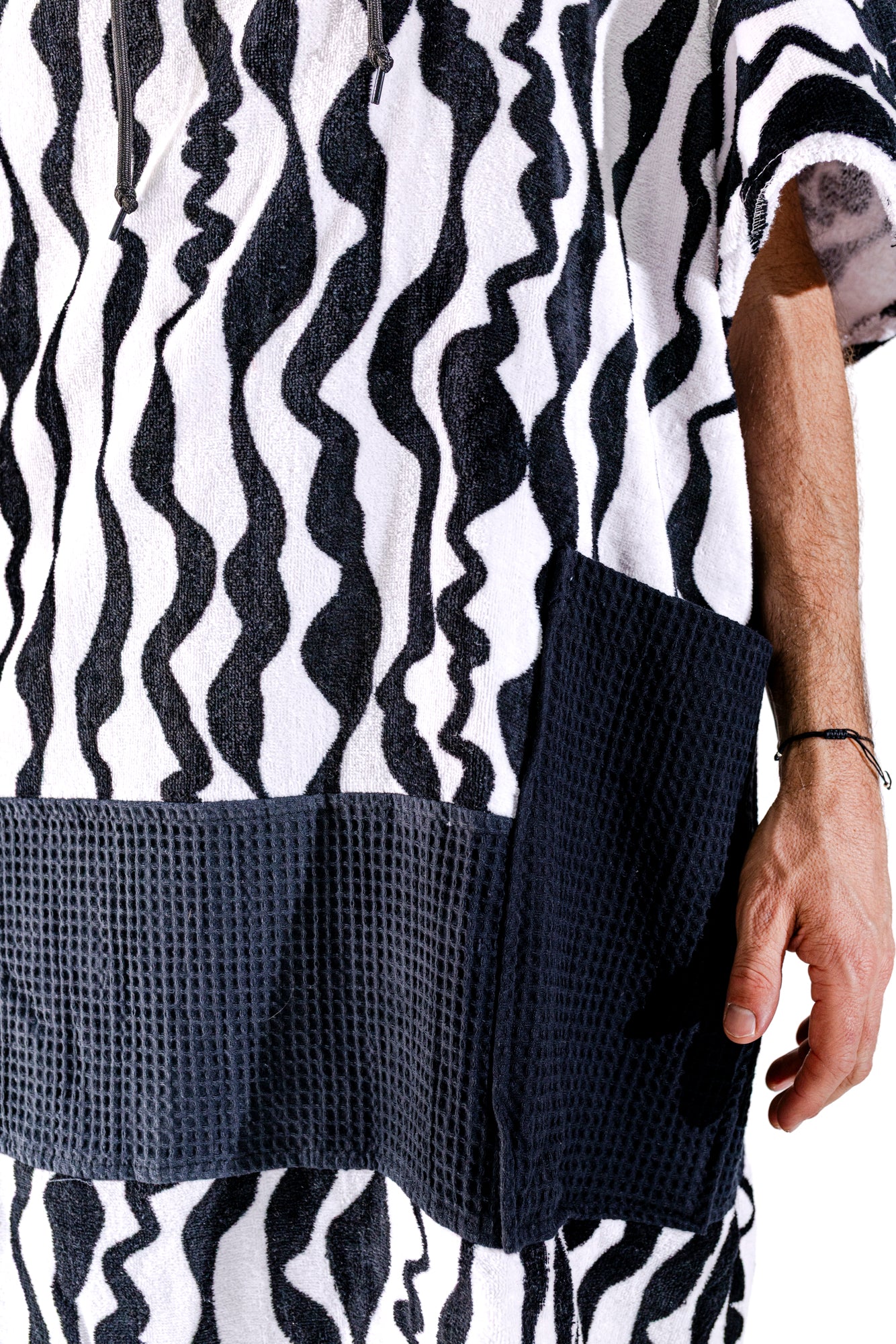 Détail poches waffle noires et motif zébré noir et blanc du poncho surf adulte ALL-IN Stripes