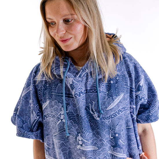 Poncho surf femme ALL-IN Surfing Madame vue trois quarts, motif vagues bleu, poche saumon visible