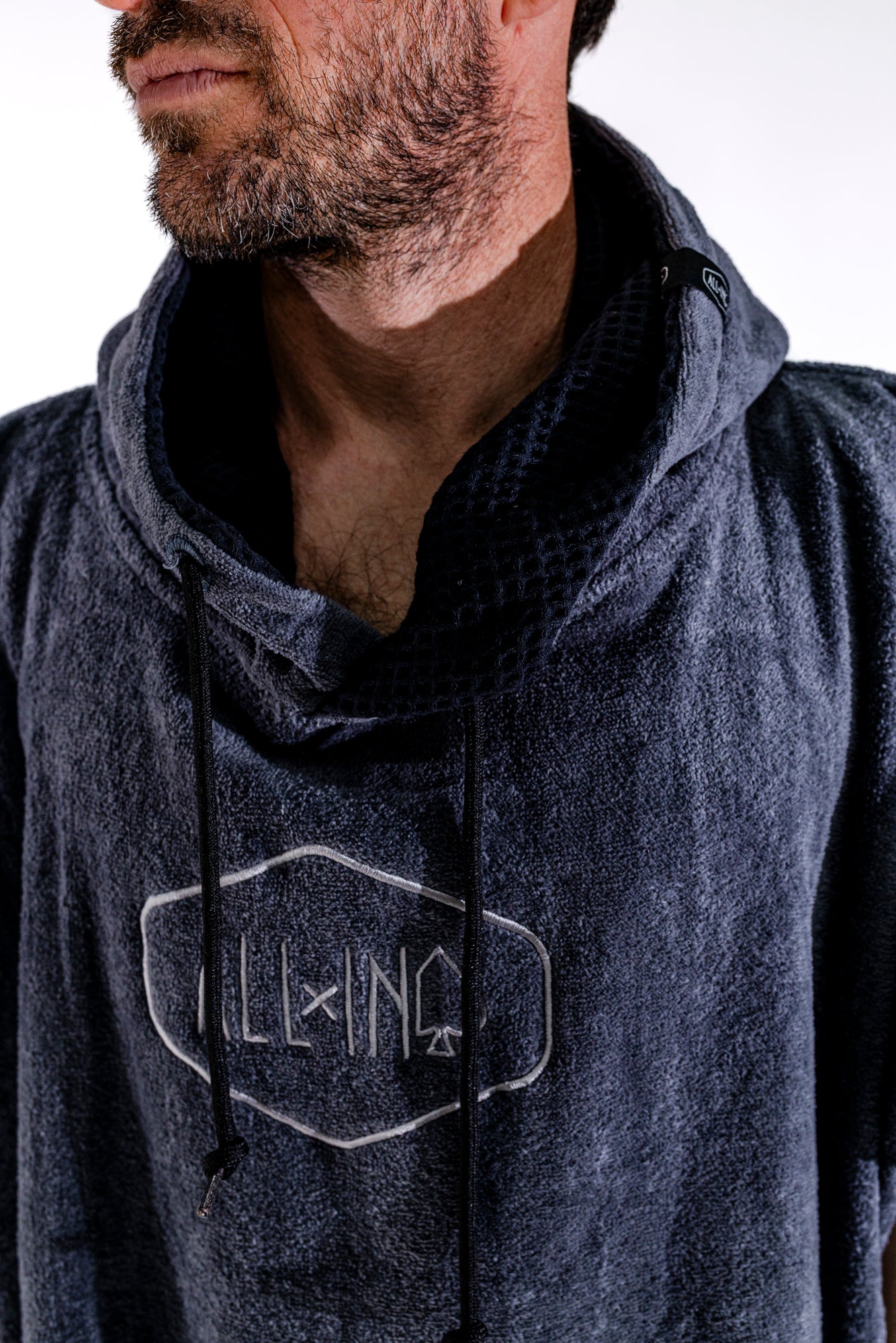 Détail logo ALL-IN brodé et col du poncho surf adulte Black Charcoal, capuche doublée noire