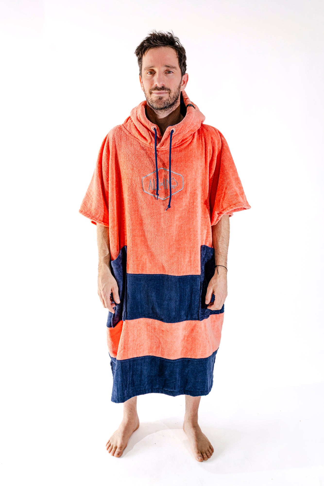 Poncho surf adulte ALL-IN Orange vue de face, coloris orange vif et bande marine, poches marines