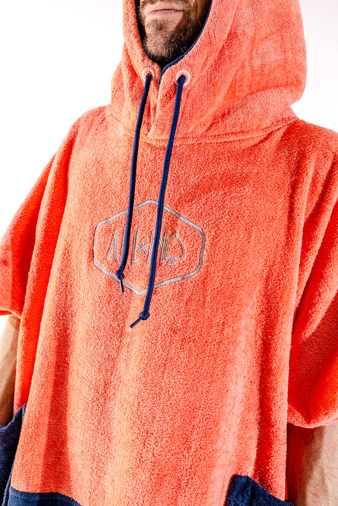 Détail capuche et logo ALL-IN brodé du poncho surf adulte Orange, cordon marine, coloris orange vif
