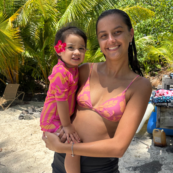  Enfant dans les bras de sa maman portant la combinaison Matis Rose ALL-IN à motif animal print rose