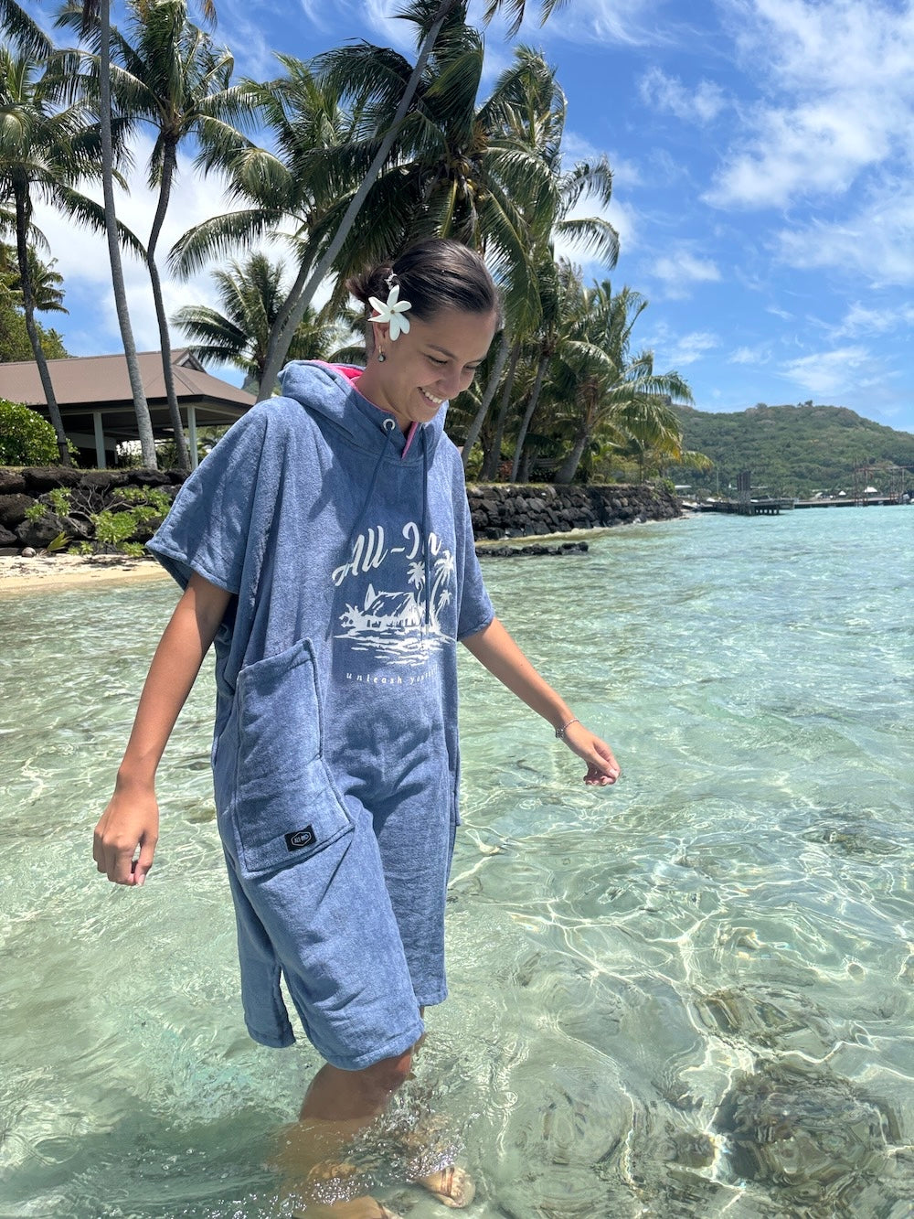 Poncho surf adulte ALL-IN Island porté en bord de mer tropical, coloris bleu indigo