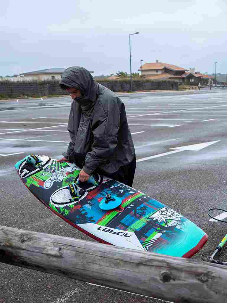 Utilisation du Storm Poncho ALL-IN en extérieur après une session de windsurf par temps pluvieux et venteux